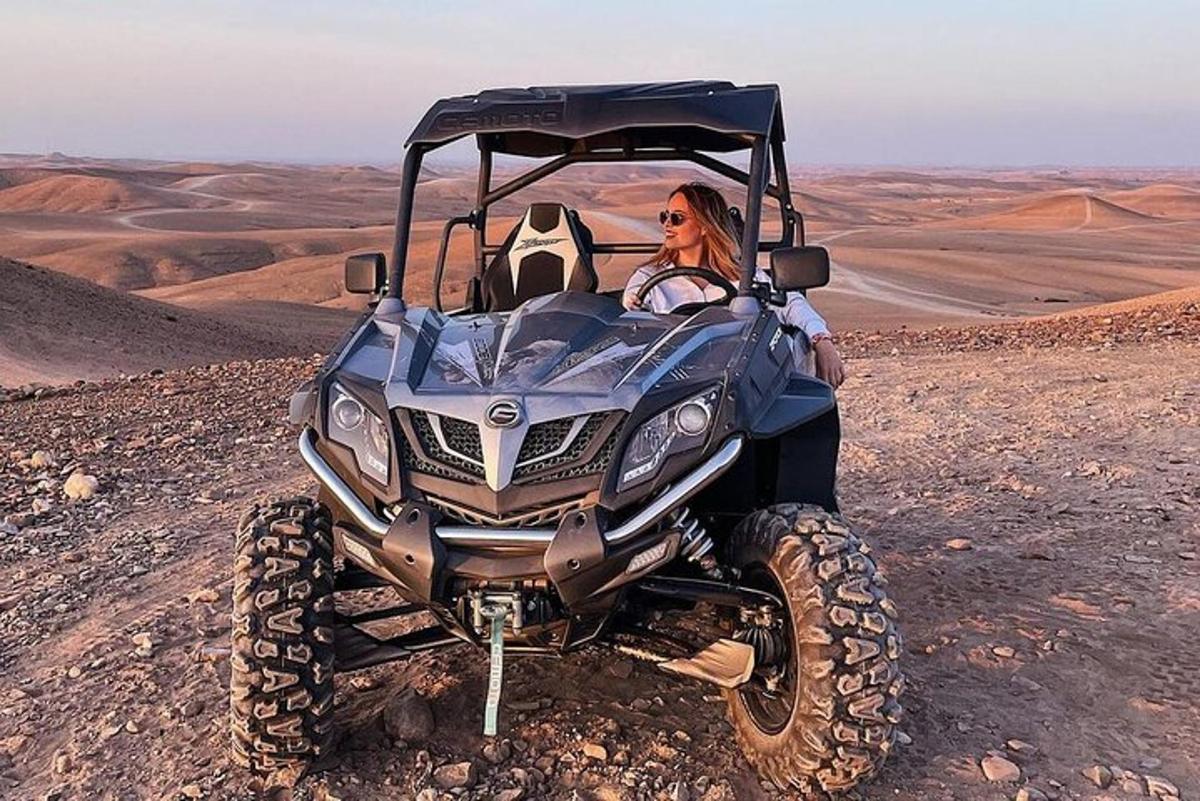 una donna seduta su un quad nel deserto