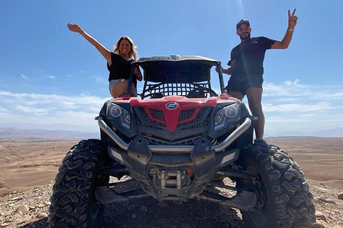 un uomo e una donna seduti in cima a un quad nel deserto