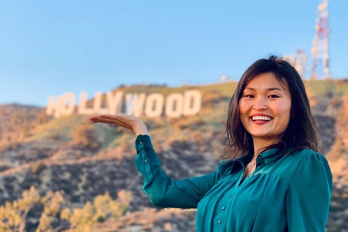 a woman standing in front of the hollywood sign