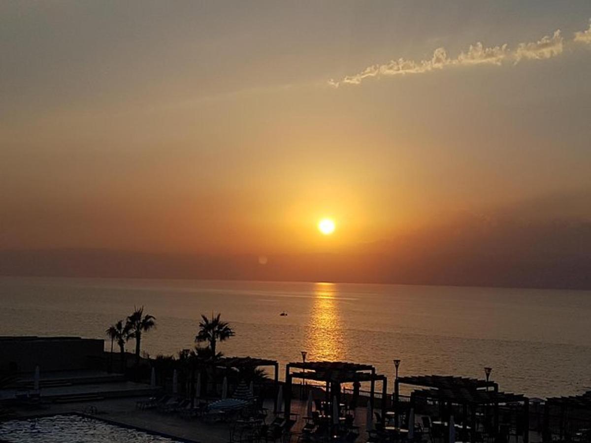 Západ slunce nad oceánem s palmami na pláži