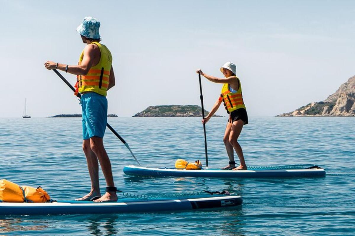 due persone sono in piedi su tavole da paddle in acqua