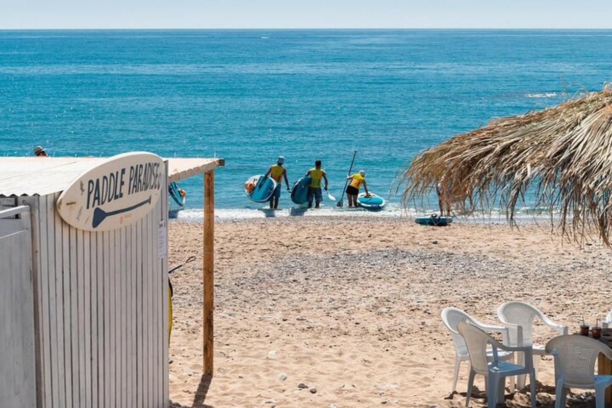 un gruppo di persone che camminano sulla spiaggia con le tavole da surf