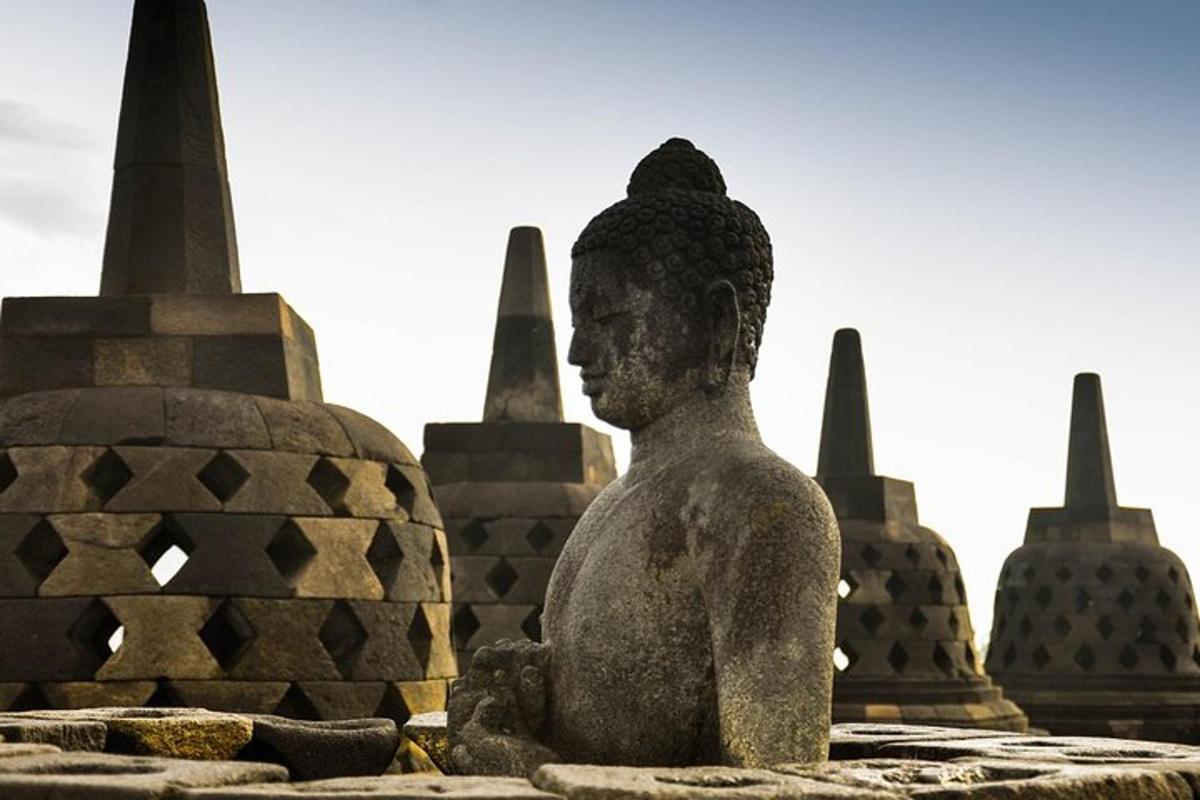 eine Statue einer Person, die vor einem Denkmal sitzt