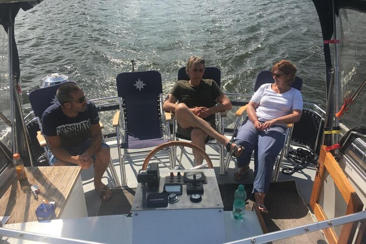 tre persone sedute su una barca in acqua