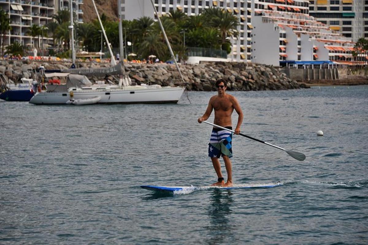 a man standing on a paddle board in the water