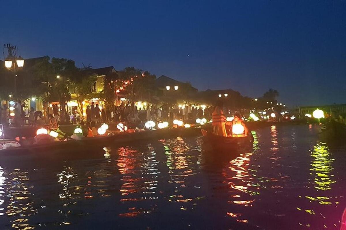 sebuah kota yang diterangi di malam hari dengan perahu di air