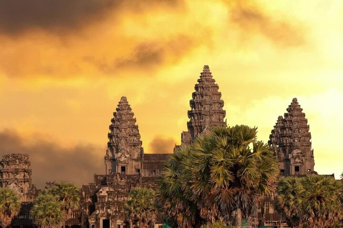 a building with three towers with palm trees in front
