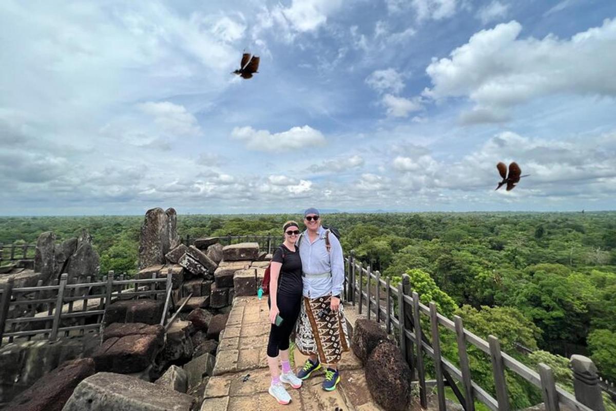 a man and a woman standing on the top of a mountain