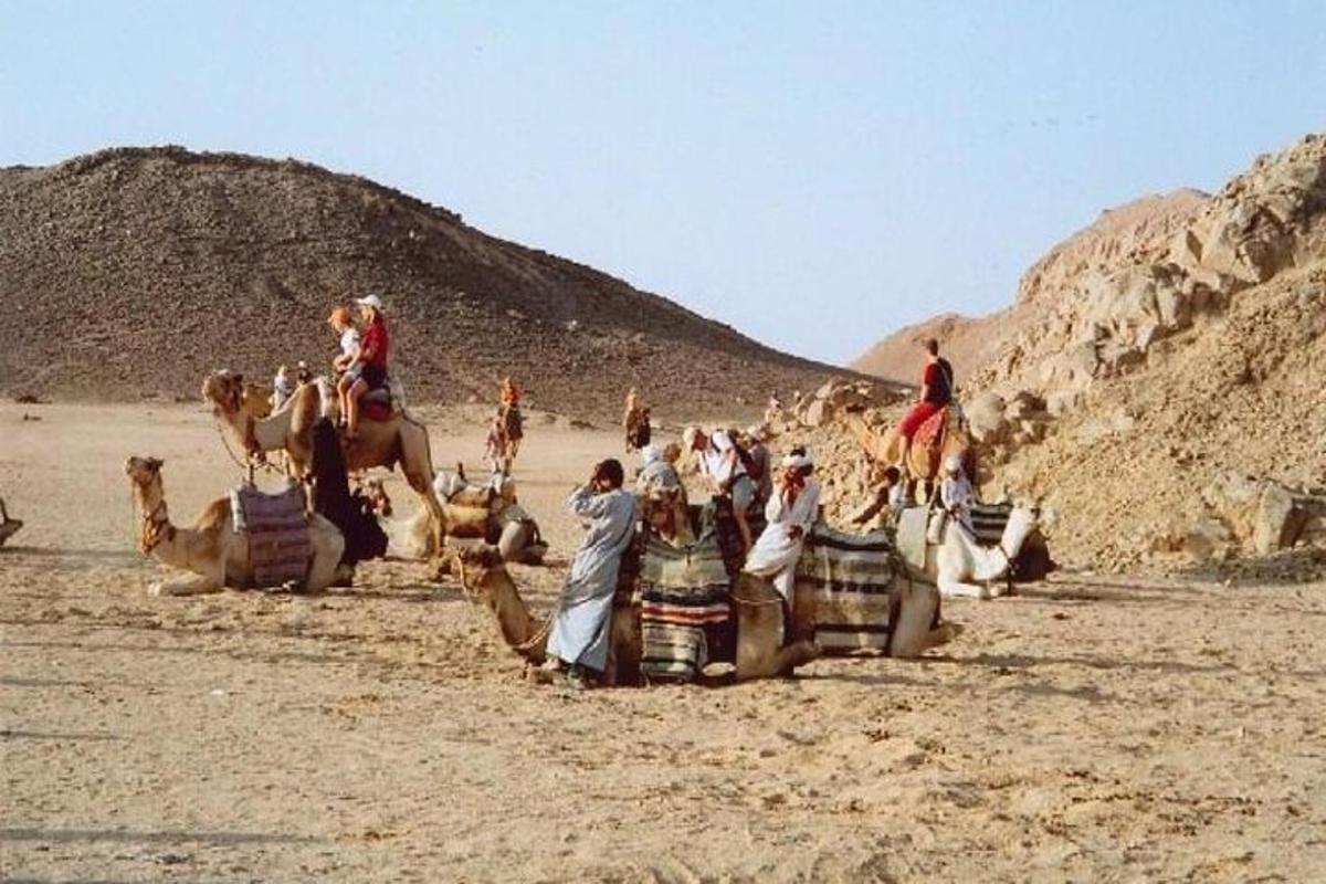 eine Gruppe von Menschen reitet Kamele in der Wüste