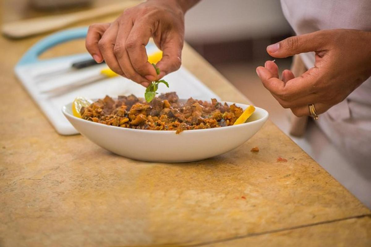 a person adding a leaf to a bowl of food