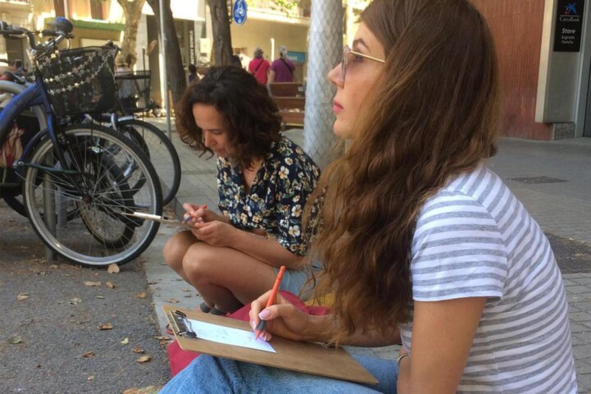 Dos mujeres sentadas en un banco mirando un libro