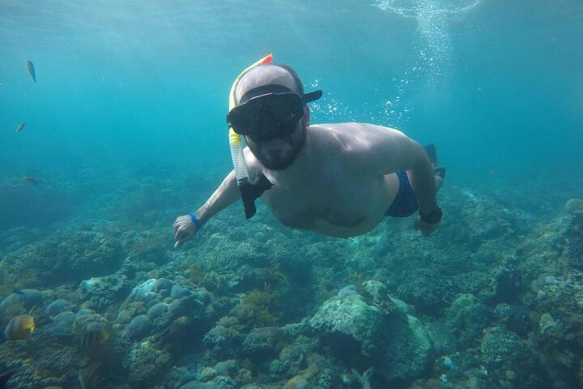 moški s klobukom in očali plava v oceanu