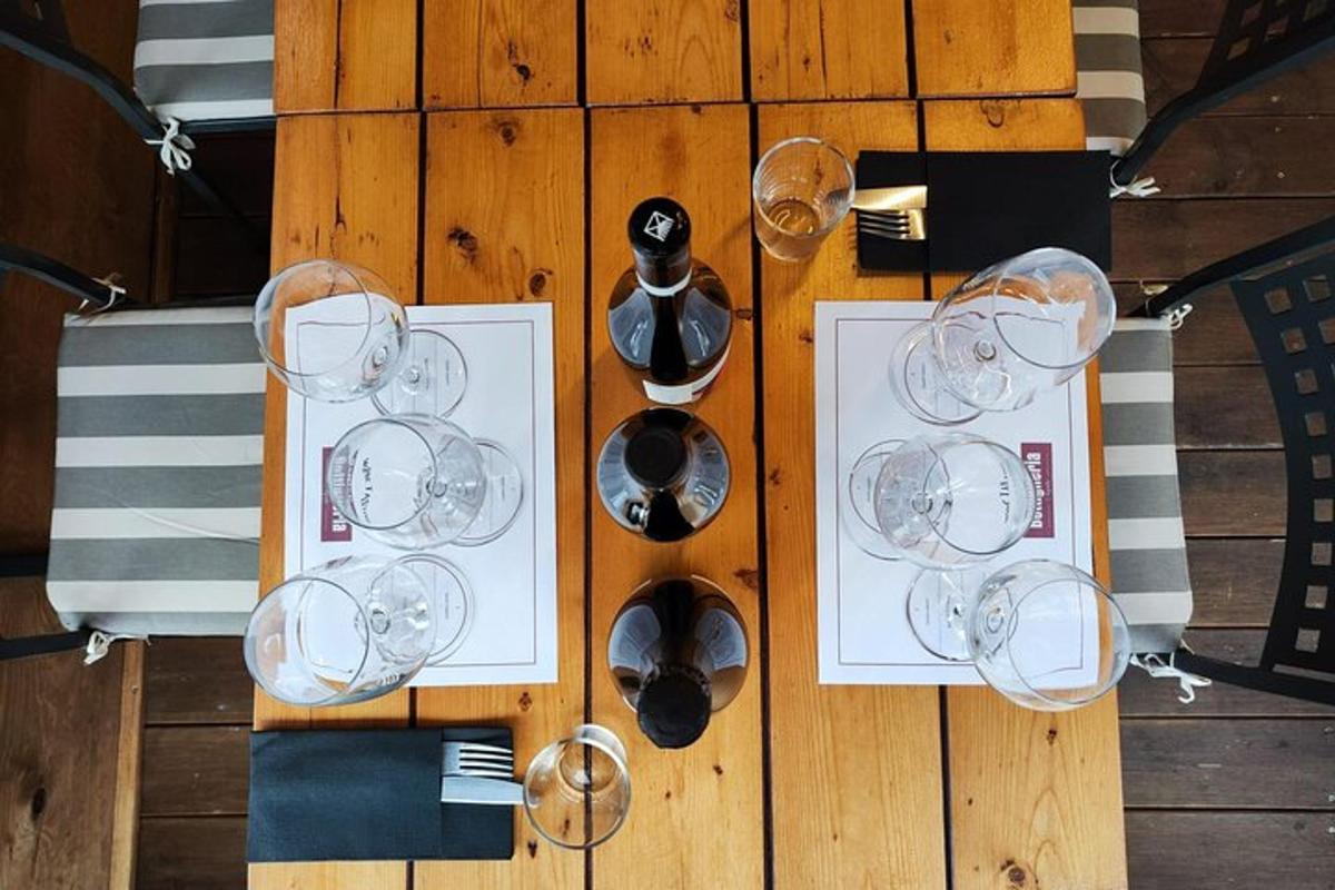 Una mesa de madera con copas de vino y campanas sobre ella.