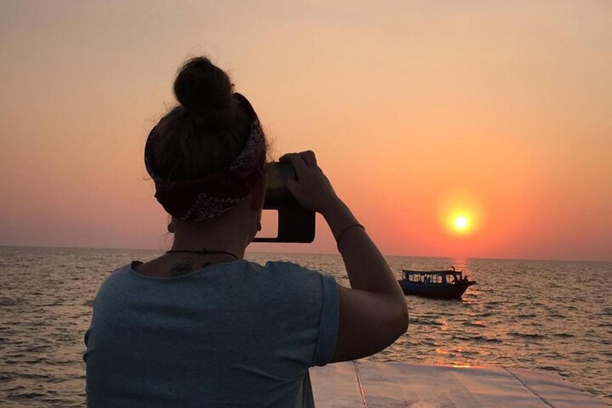 una donna che scatta una foto del tramonto