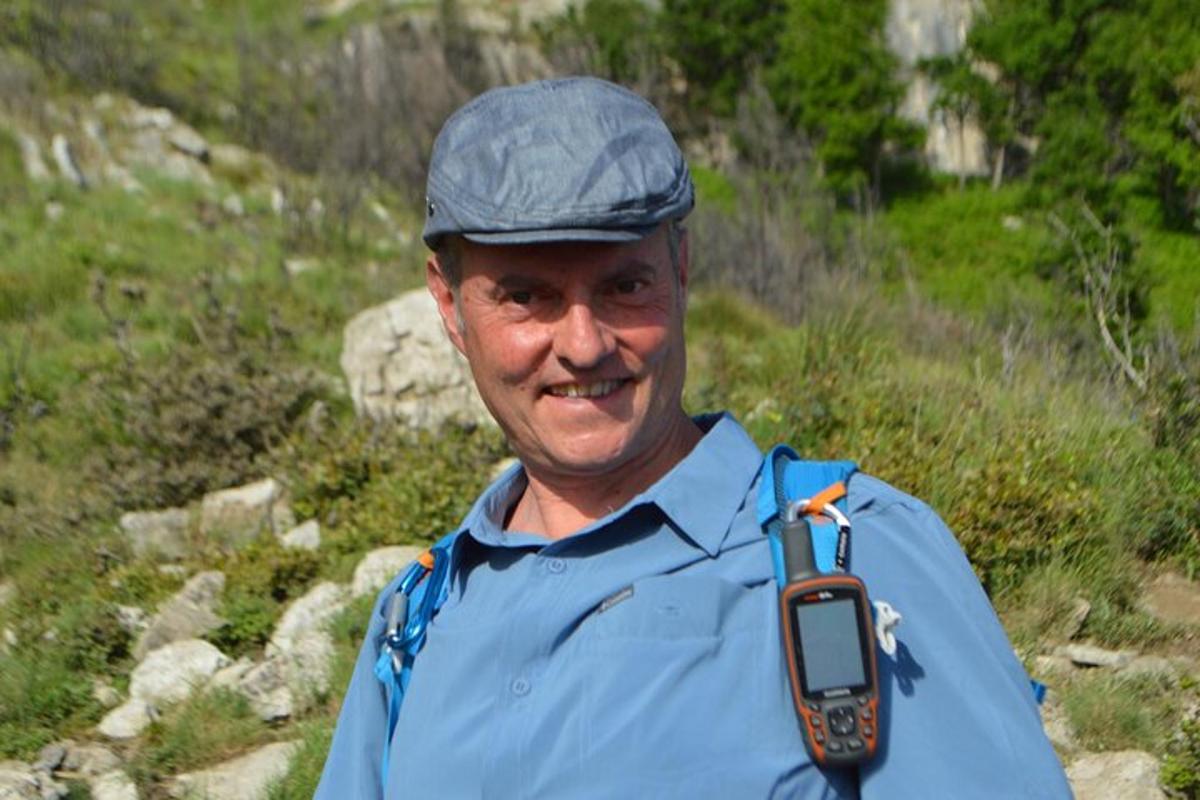 muž s kloboukem a mobilním telefonem kolem krku