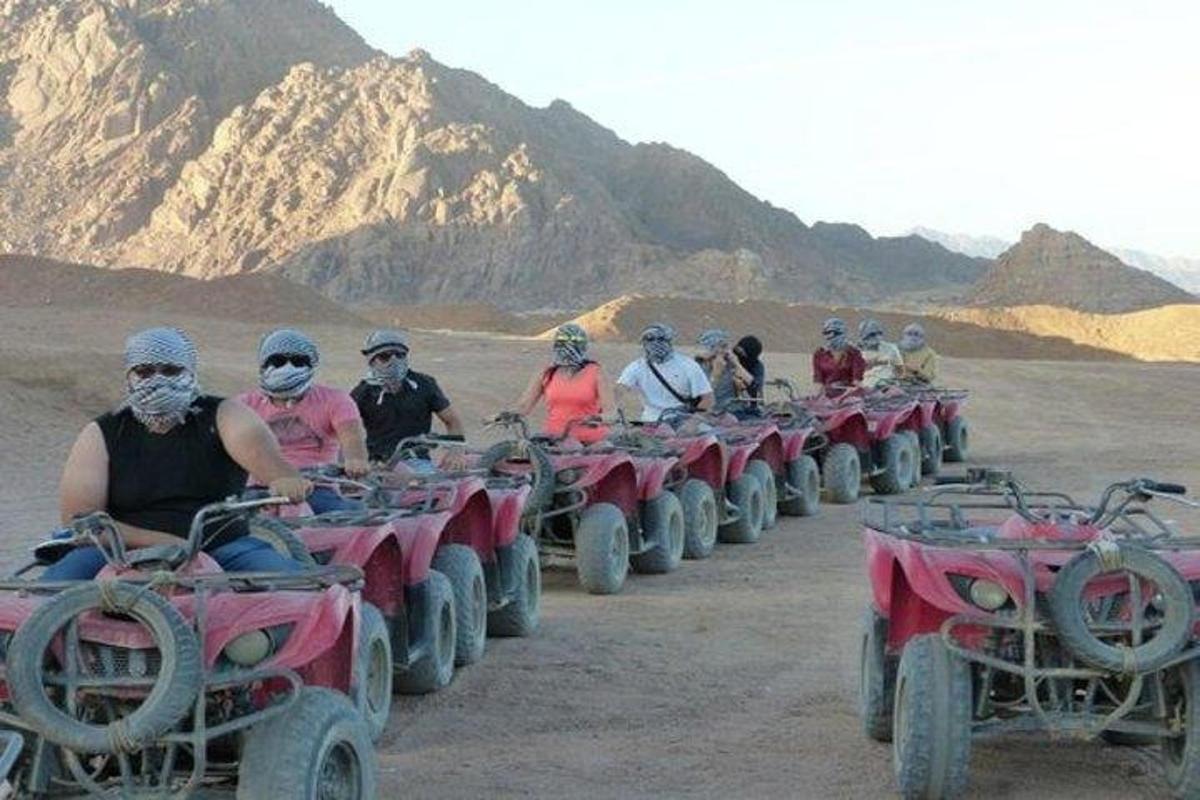 sekumpulan orang menunggang atv di padang pasir