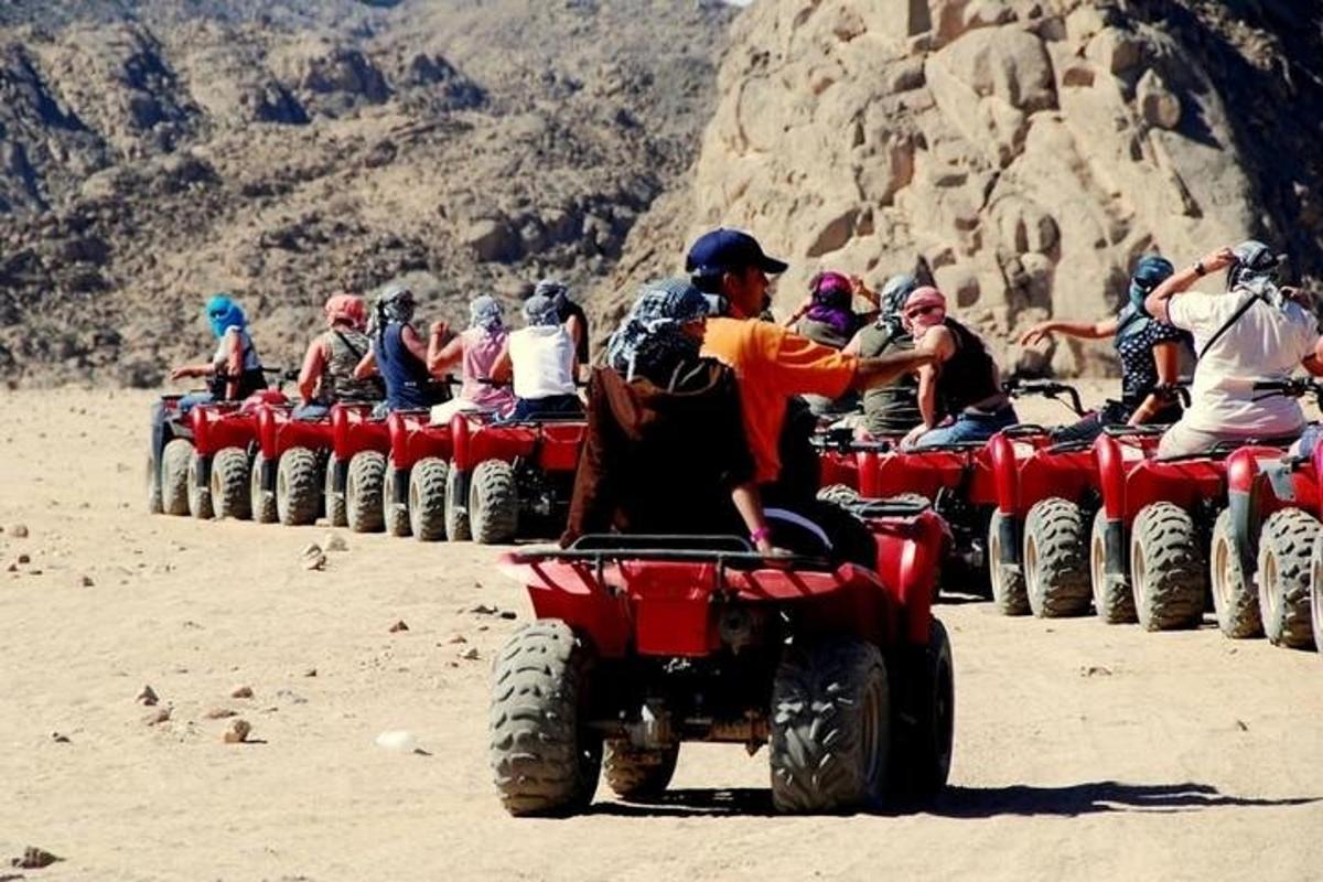 sekumpulan orang menunggang atv di padang pasir