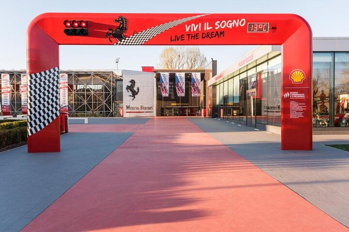 a red arch with a walkway in front of a building