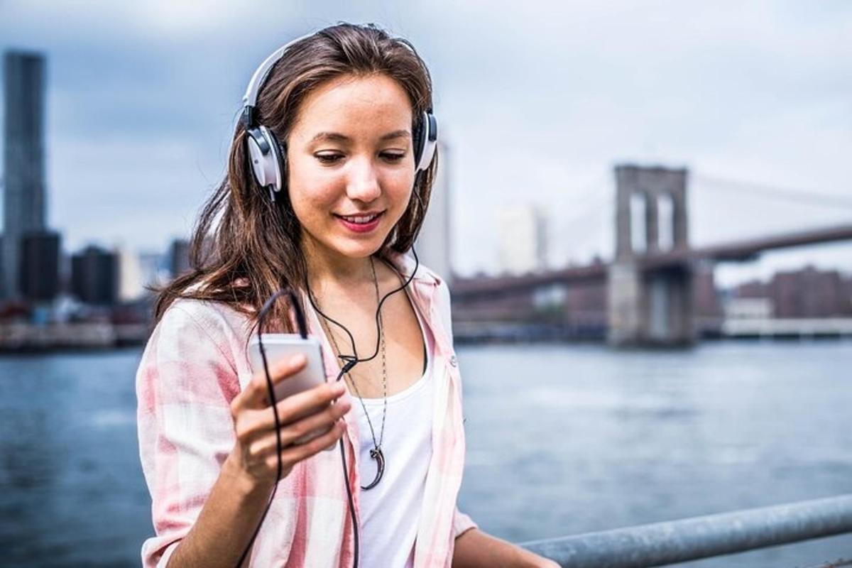 a woman wearing headphones looking at her cell phone