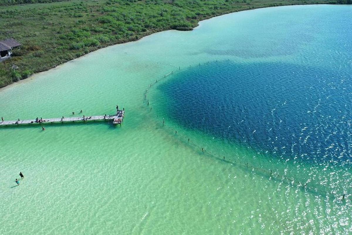 un gruppo di persone in piedi su un molo in acqua