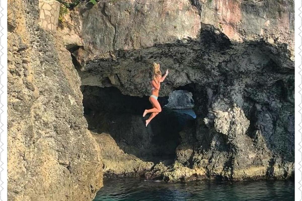 žena skákající z útesu do vody