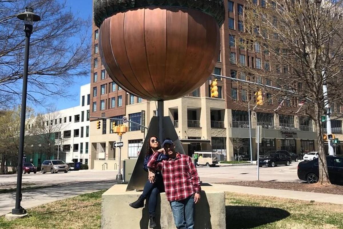 a man and a woman standing in front of a bowl statue