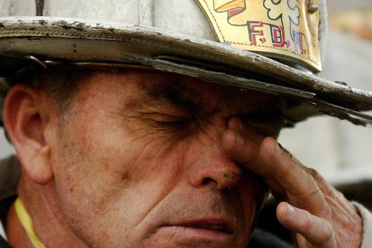 Ένας ηλικιωμένος άνδρας που φοράει καπέλο με το χέρι του στο πρόσωπό του