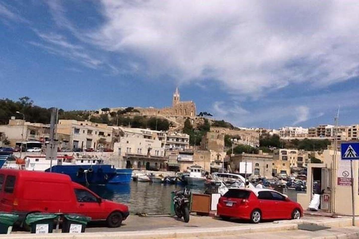 two cars parked next to a marina with a castle