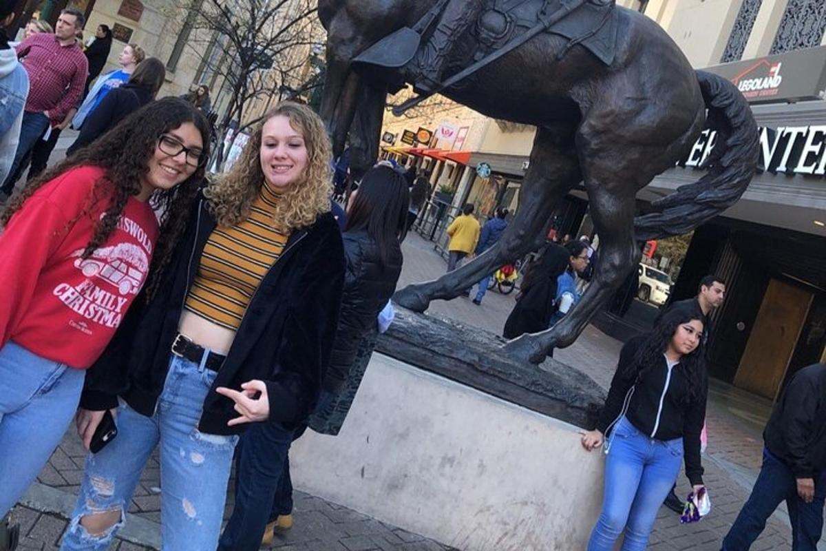 două femei stând lângă o statuie a unui cal