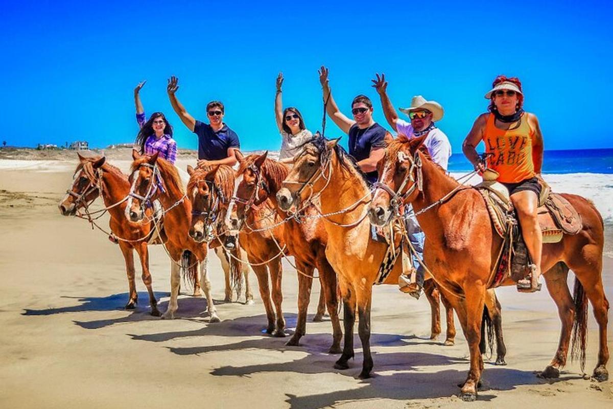 un gruppo di persone a cavallo sulla spiaggia