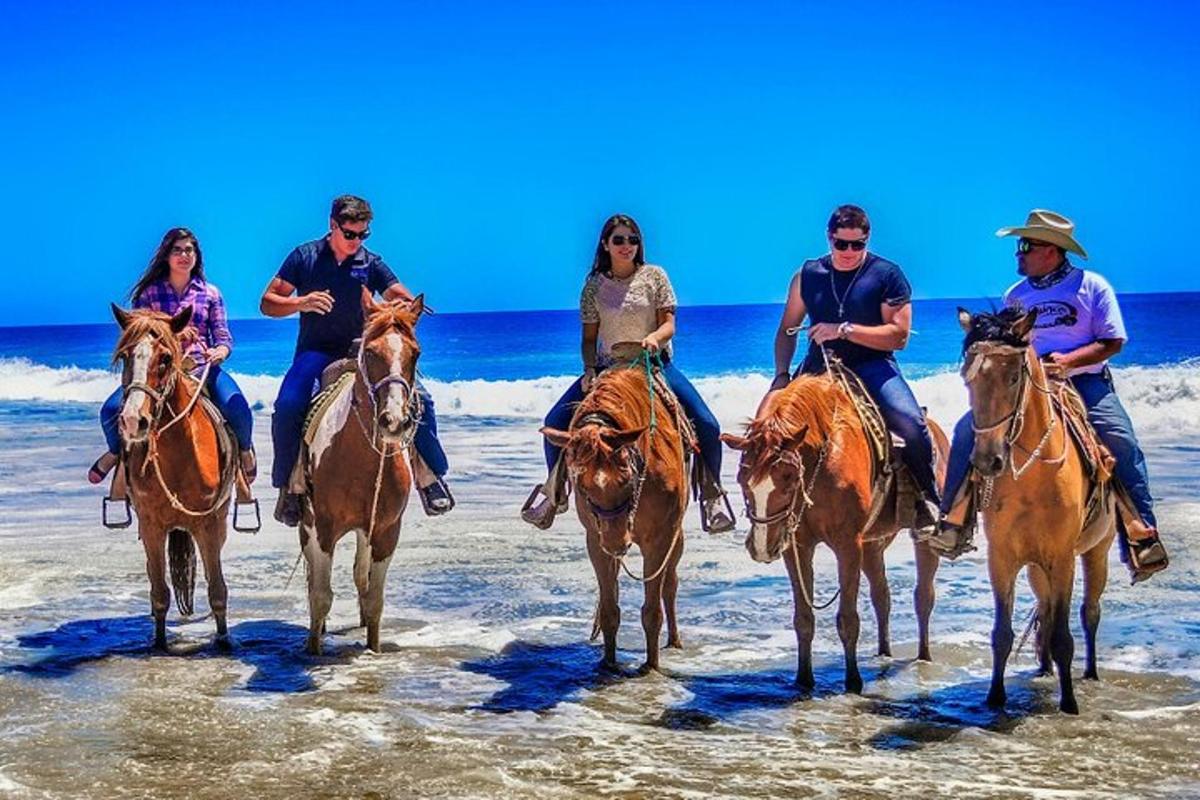 un gruppo di persone a cavallo sulla spiaggia
