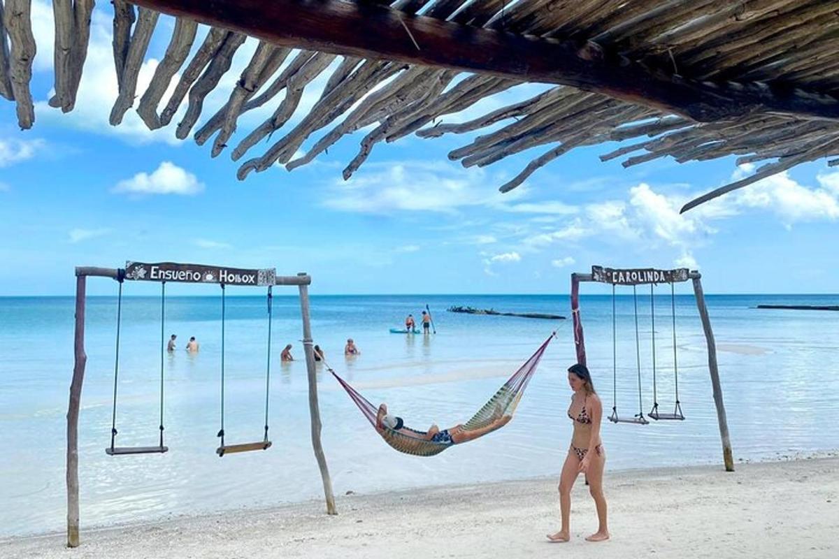seorang wanita duduk di buaian di pantai