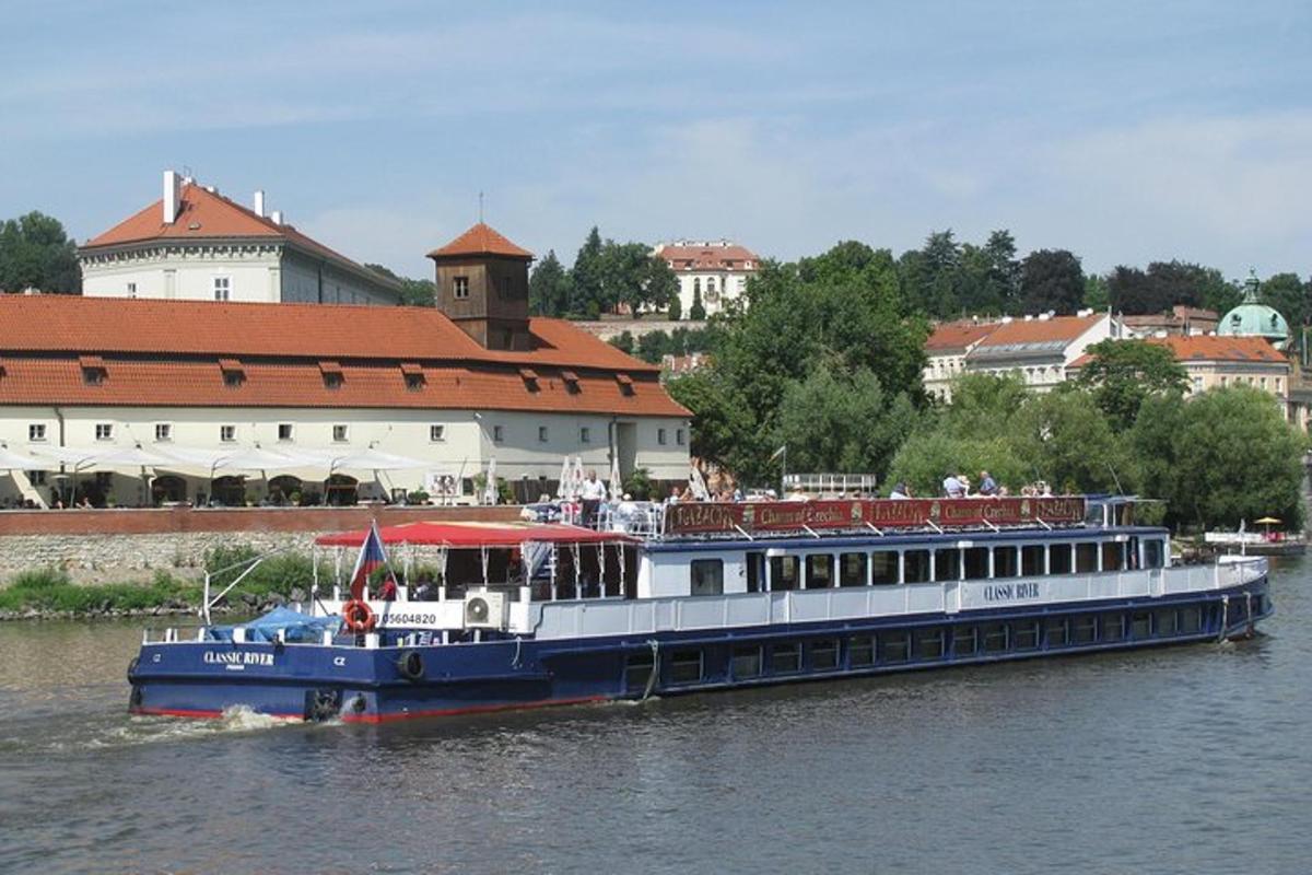 um barco azul e branco em um rio com edifícios