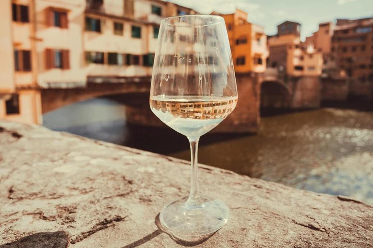 un bicchiere di vino seduto su una sporgenza vicino a un fiume