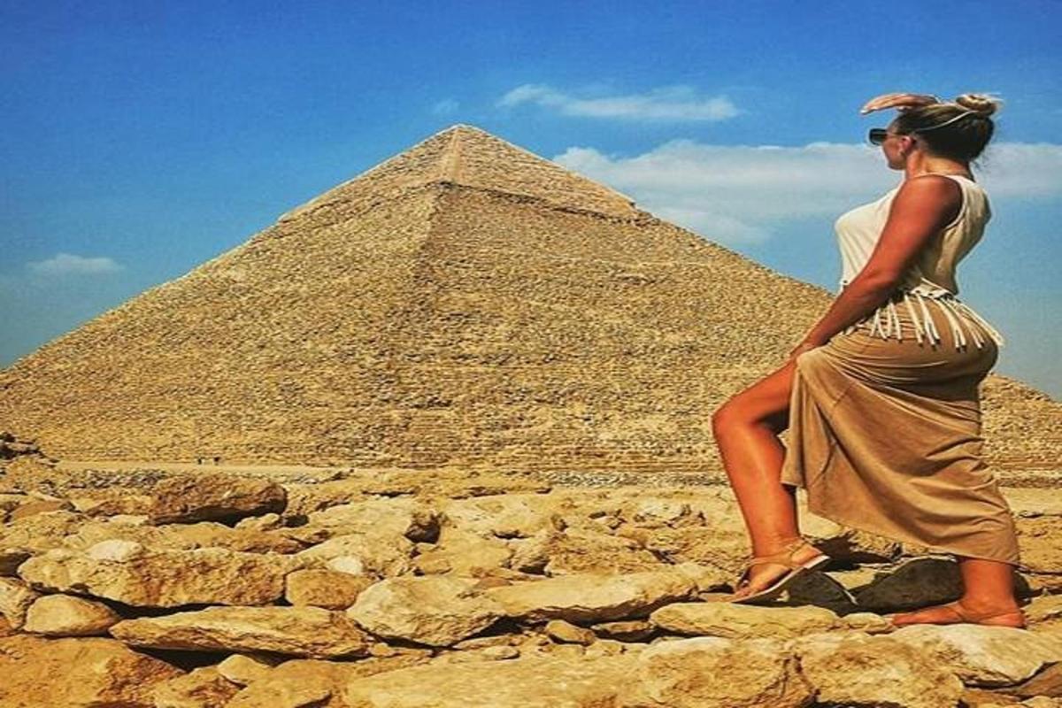 uma mulher em pé em frente a uma pirâmide
