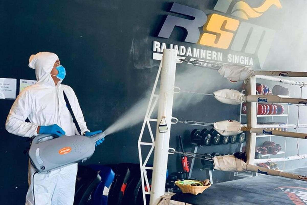 a person standing in a room disinfecting a sign