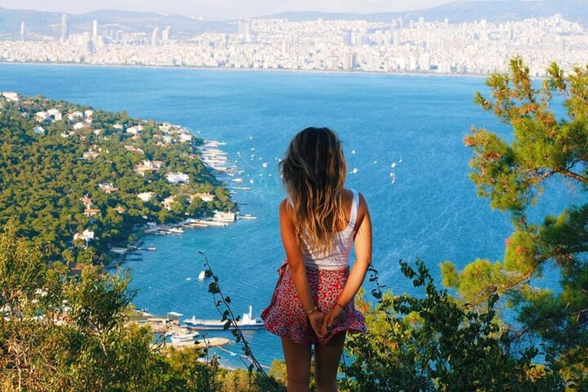 una donna in piedi su una collina che guarda l'oceano