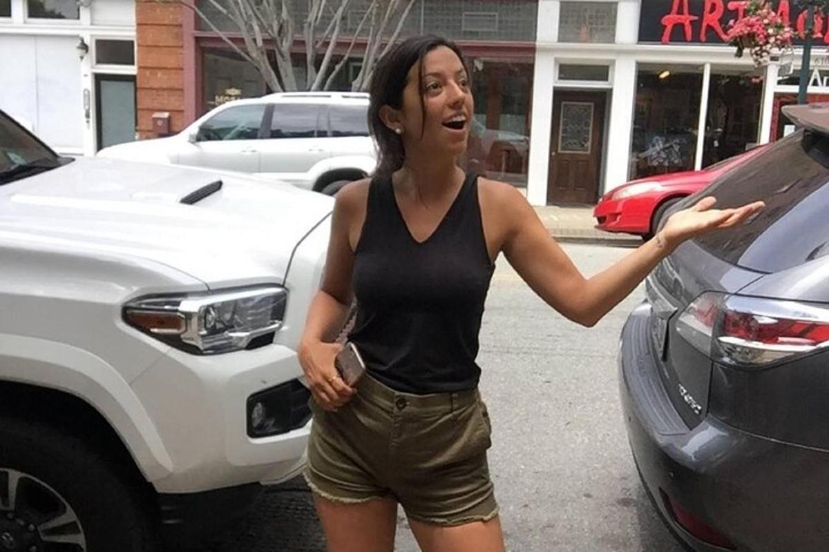 una donna è in piedi accanto a un'auto bianca