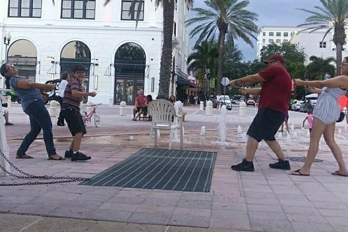 un gruppo di persone che giocano a frisbee in una fontana