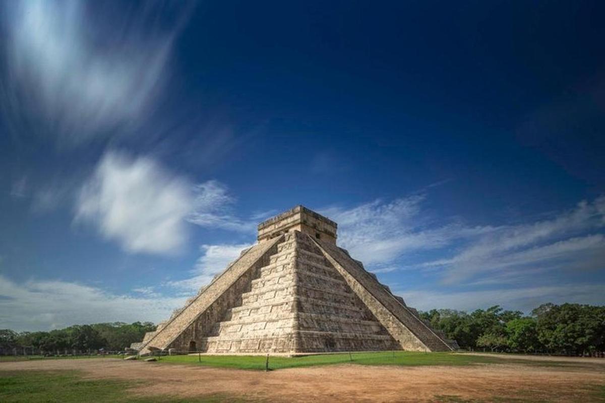uma estrutura piramidal com um céu azul ao fundo