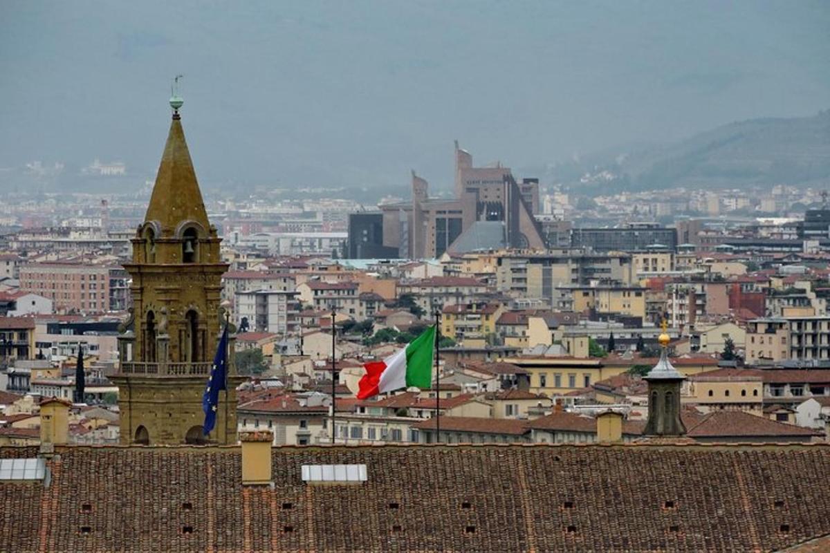 a view of a city with a clock tower and two flags