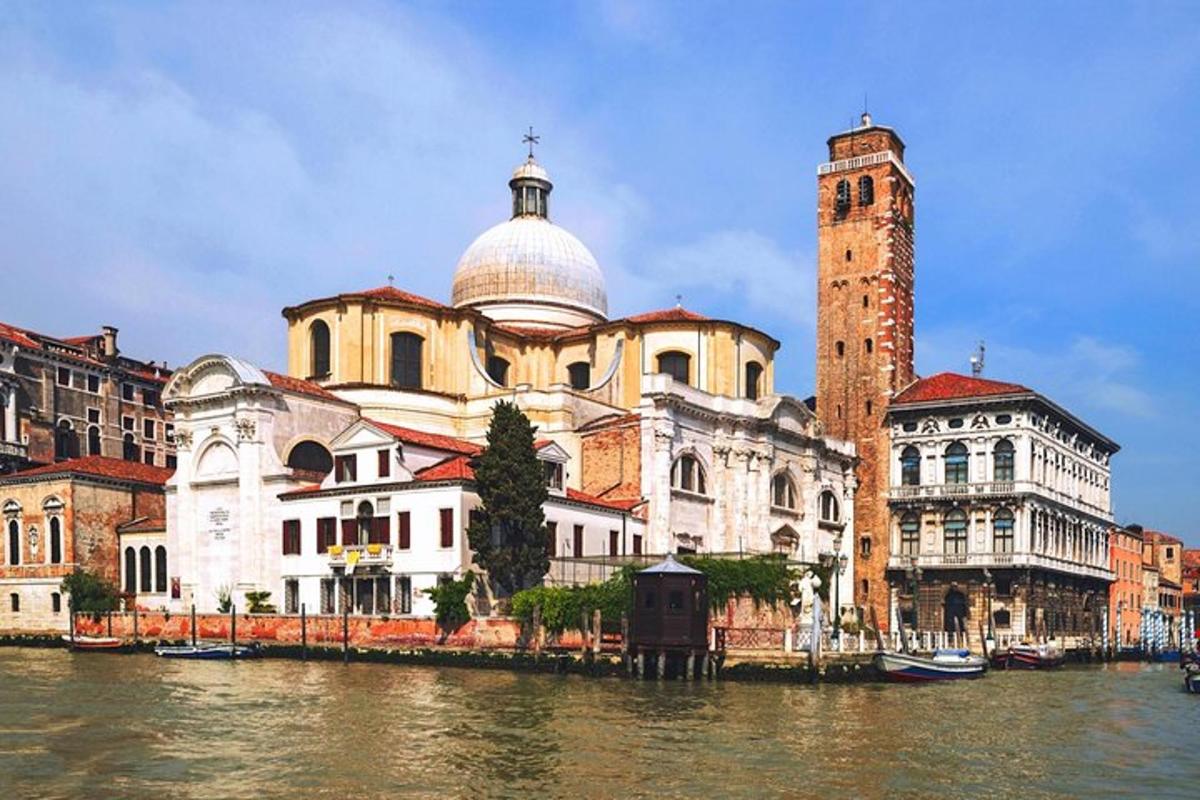 ein großes Gebäude mit einem Uhrenturm neben einem Fluss