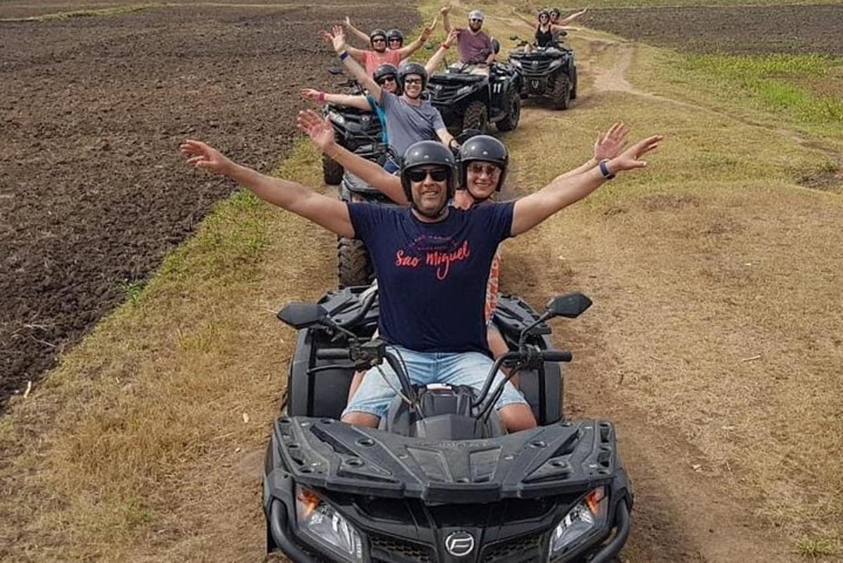 Un grupo de personas conduciendo vehículos todo terreno por un camino de tierra.