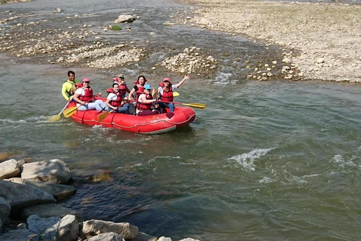 een groep mensen in een rood vlot op een rivier