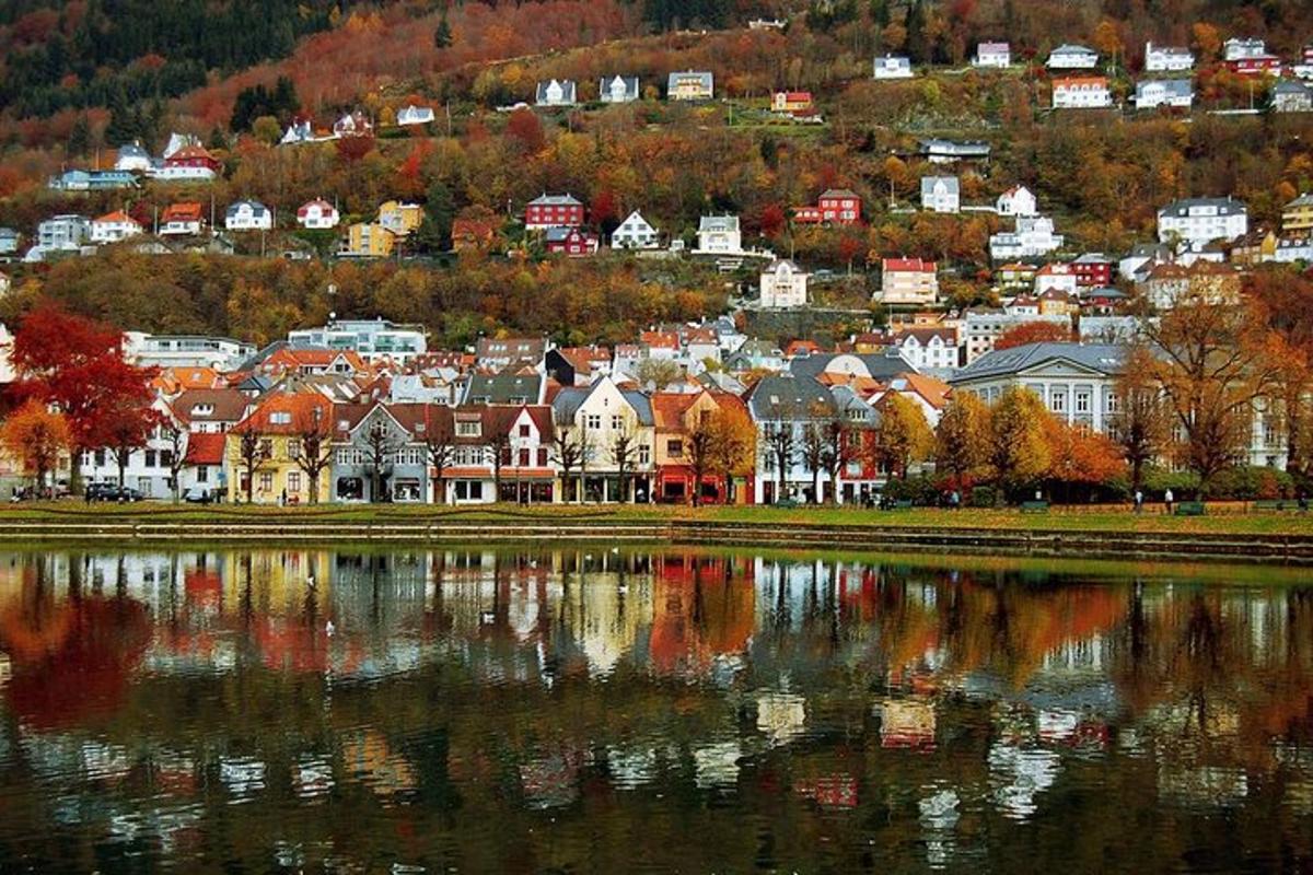 a town sitting on top of a hill next to a lake