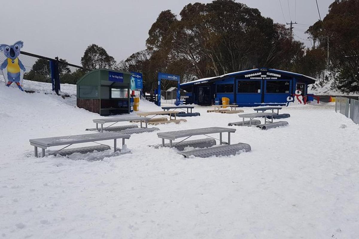 een groep picknicktafels in de sneeuw