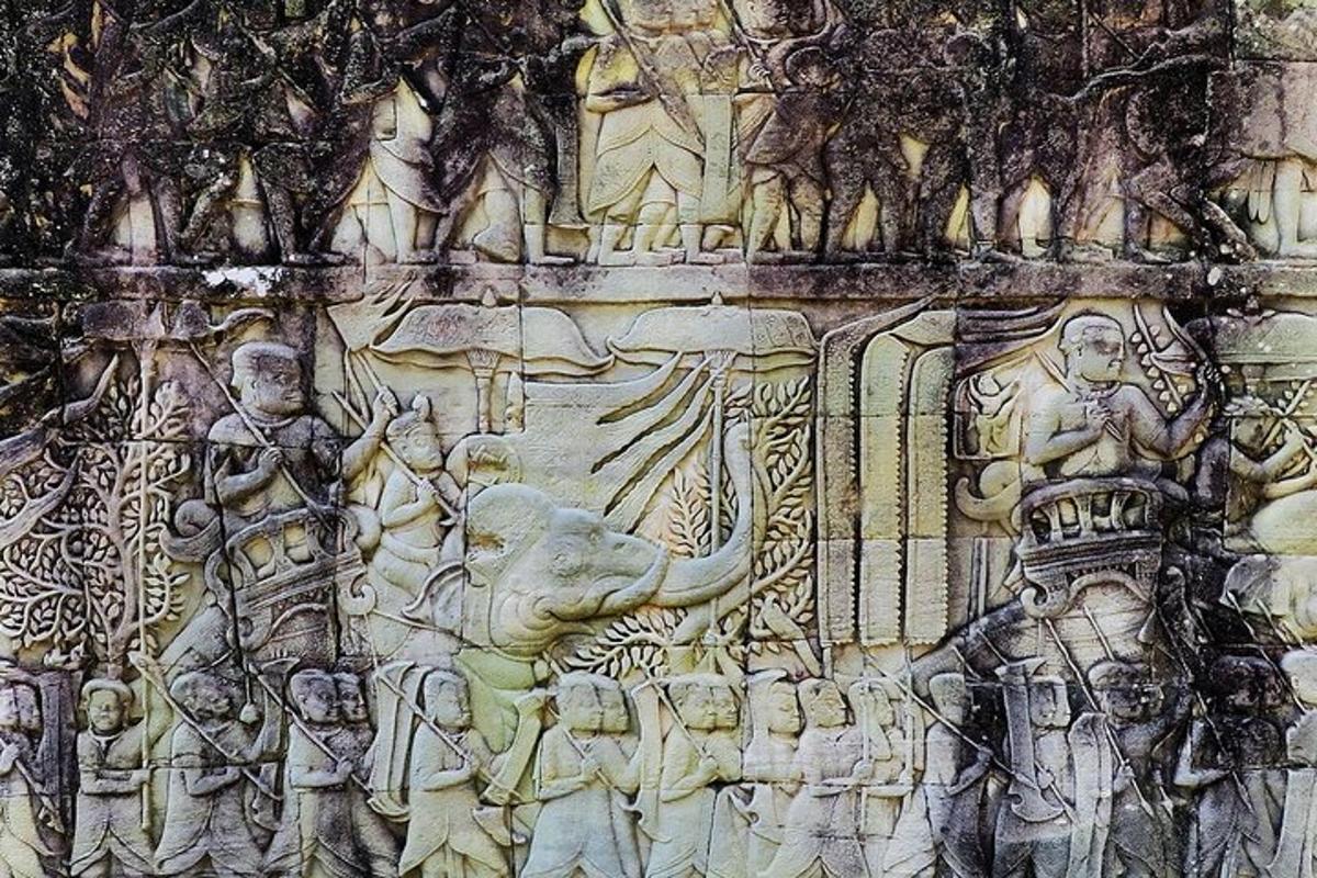 ένας πέτρινος τοίχος με ανάγλυφο ανθρώπων και ελεφάντων