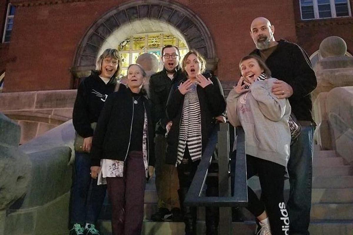 a group of people standing next to a sign