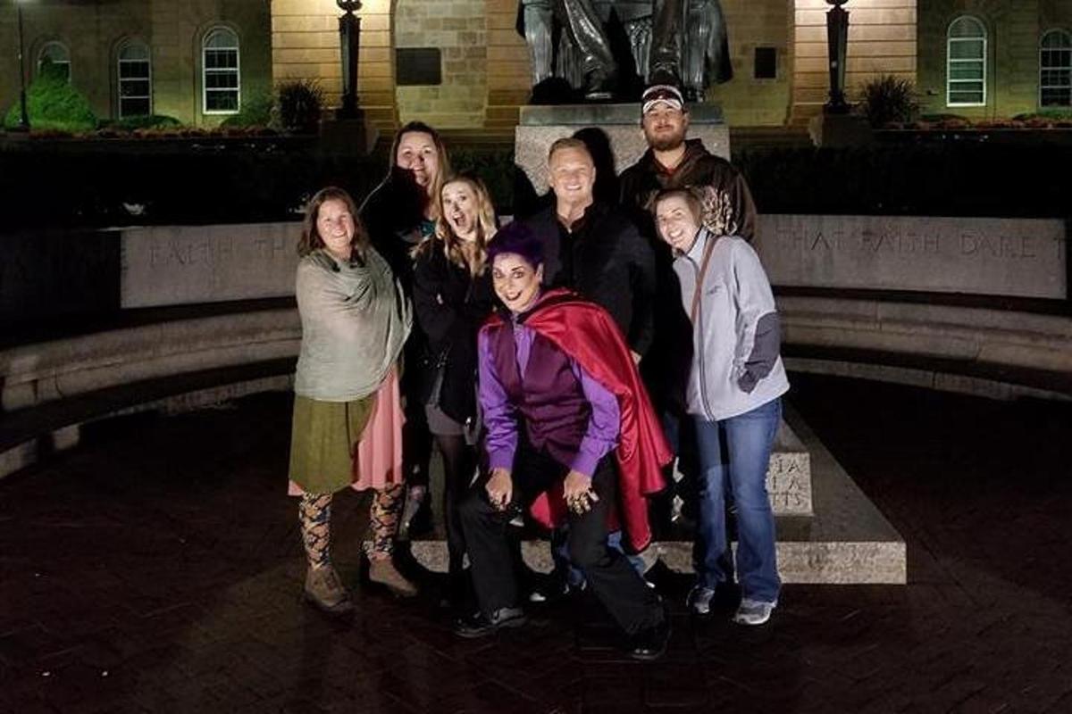 a group of people posing in front of a statue