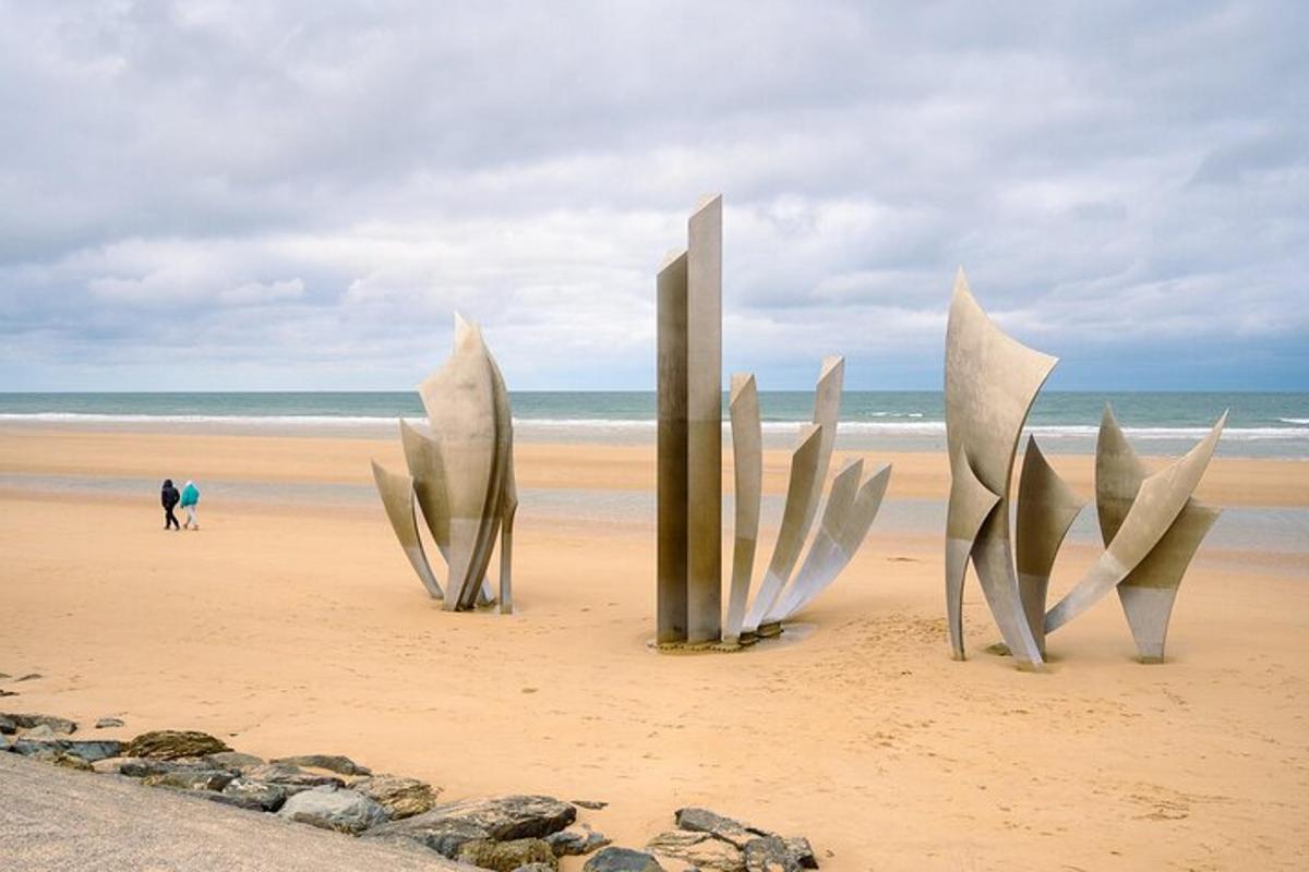 a sculpture on a beach with the ocean in the background